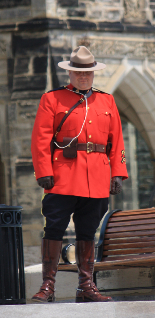 An officer of the Royal Canadian Mounted Police (a "Mountie") standing guard on Parliament Hill in Ottawa, Ontario. Image from Wiki Media Commons.